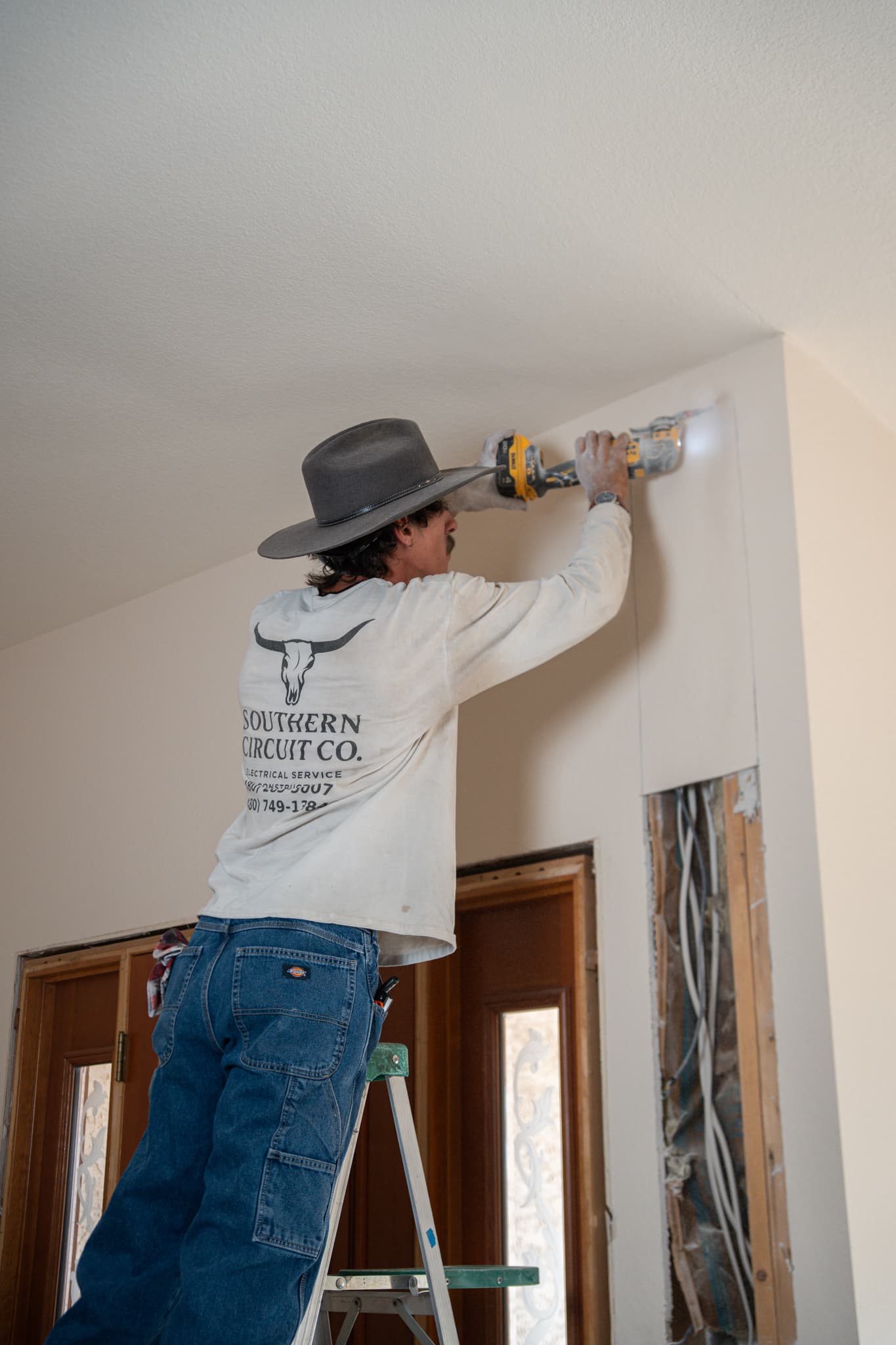 Electrician installing precision lighting in a new-build interior